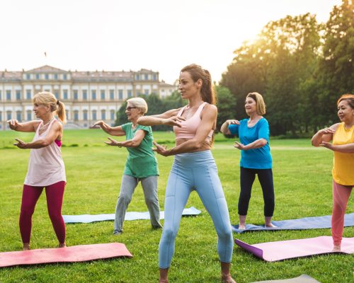 Senior women training with fitness coach at park Senior women training with fitness coach at park